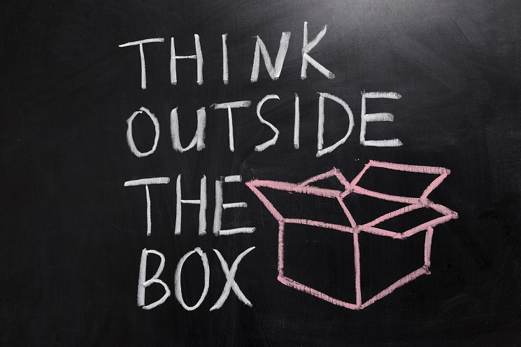 Kreidezeichnung von einer Box, links daneben der Schriftzug "Think outside the box"